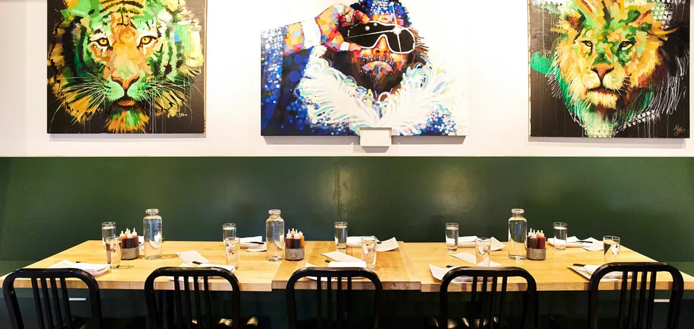 Dining tables beneath artwork at Revel