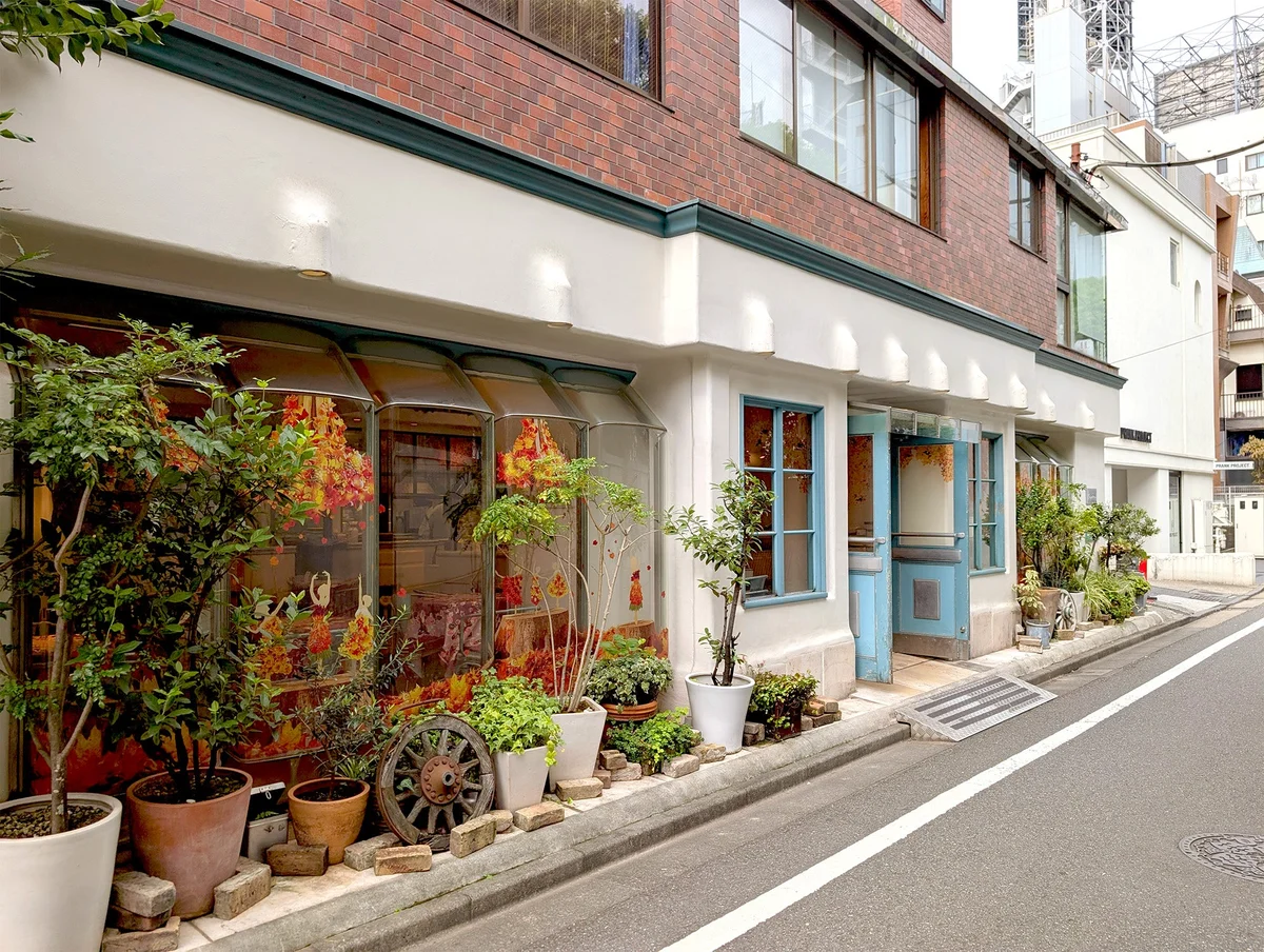 Qu’il fait bon — Aoyama — Branch entrance/exterior at aoyama from its operator branch gallery; unlabelled display tarts are not identified as current menu items.
